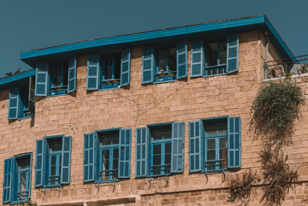 stone building with blue windows and shutters in Tel Aviv