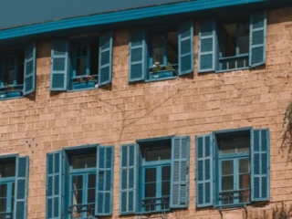 stone building with blue windows and shutters in Tel Aviv