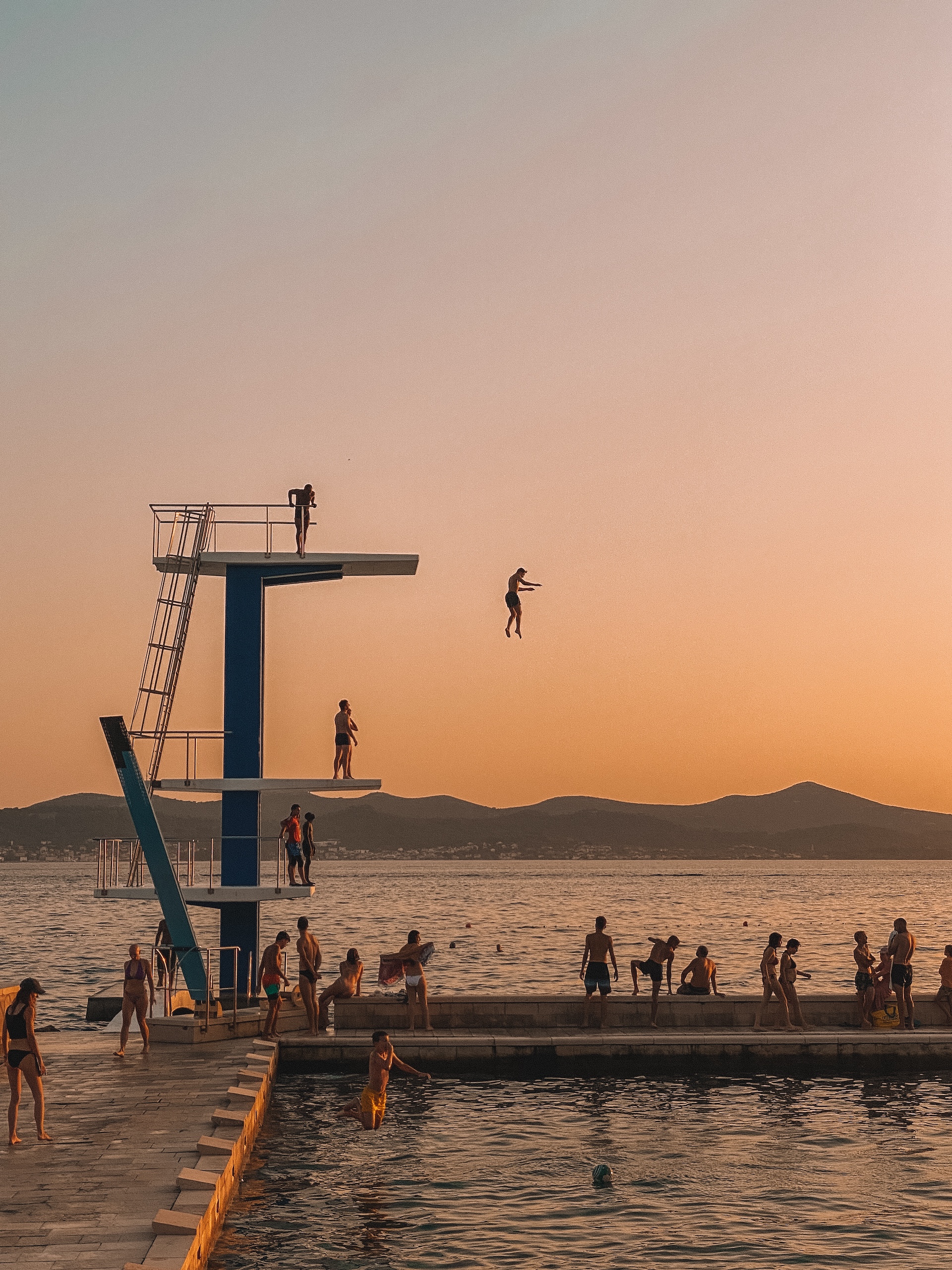 people jumping off the Zadar Diving Board during sunset