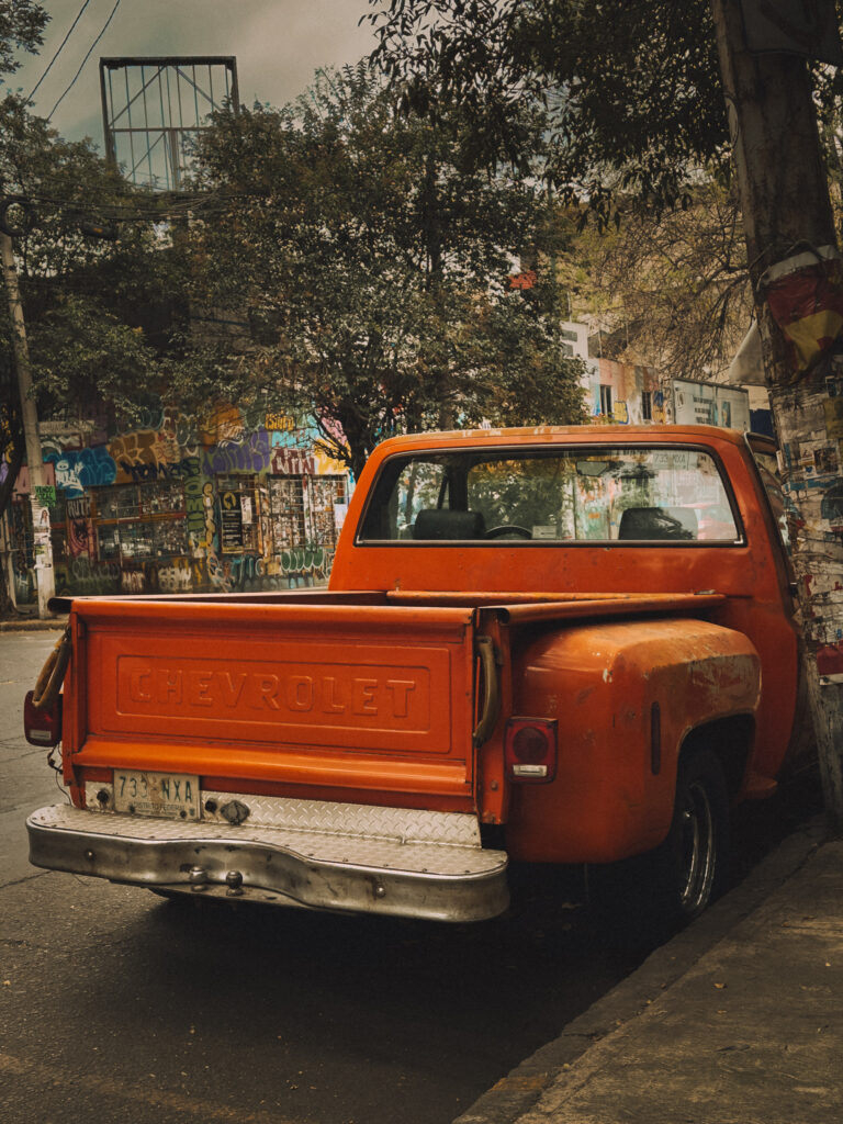 An old orange Chevrolet pickup truck on a Mexico City street